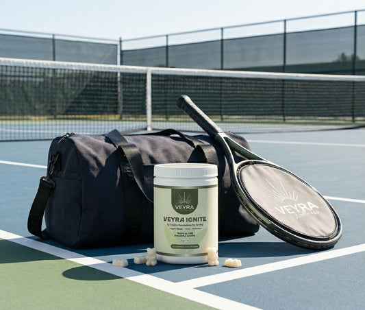 Veyra Ignite creatine gummies bottle next to a gym bag and tennis equipment